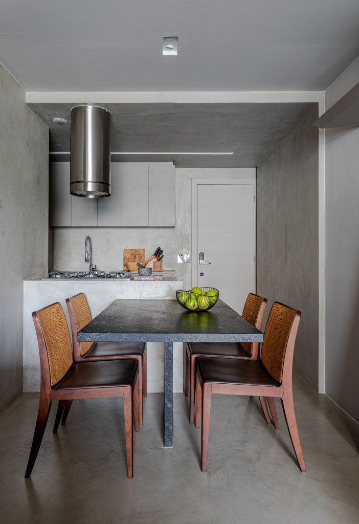 Cozinha integrada à sala de estar com paleta cinza e cimento