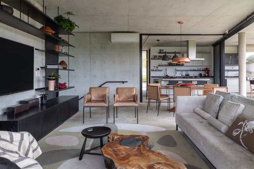 Sala de estar com parede de concreto e décor neutro
