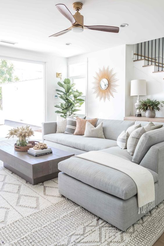 Sala de estar com sofá cinza e tapete branco