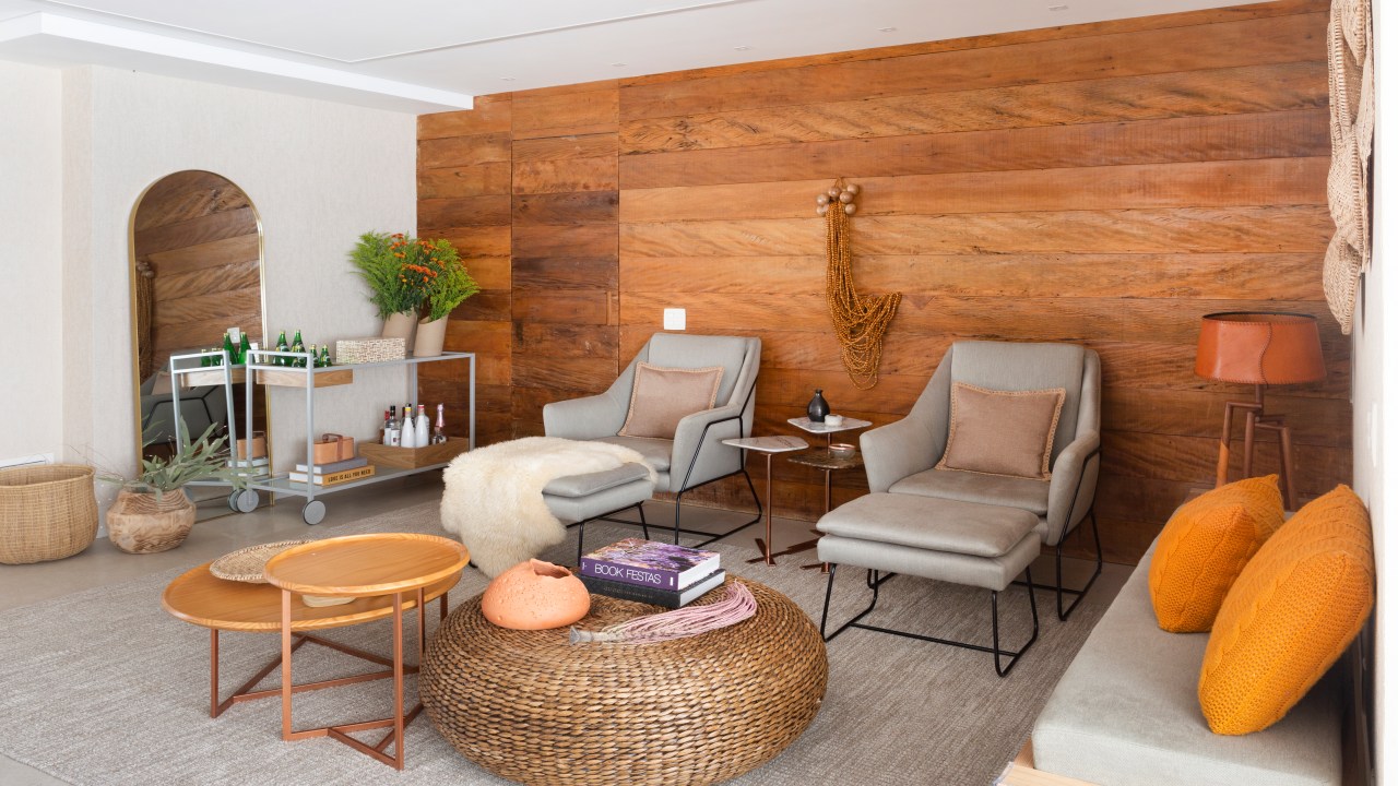 Sala de estar com painel de madeira e poltronas cinza