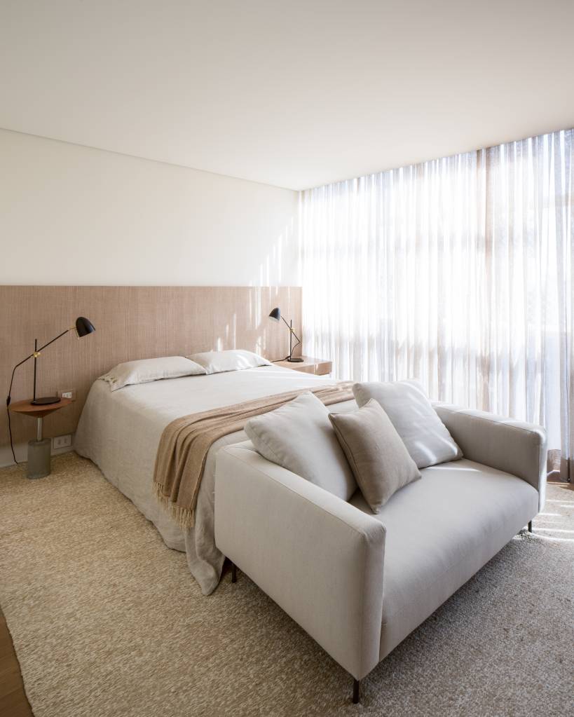 Quarto com décor neutro, sofá na frente da cama