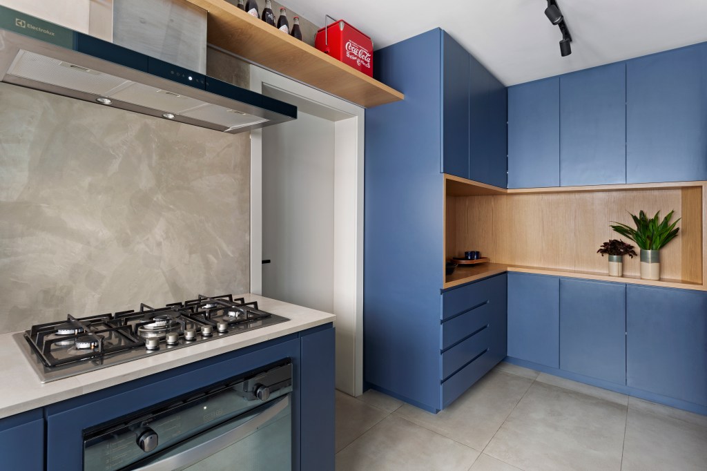 Cozinha com marcenaria azul e detalhes em cinza e cimento queimado