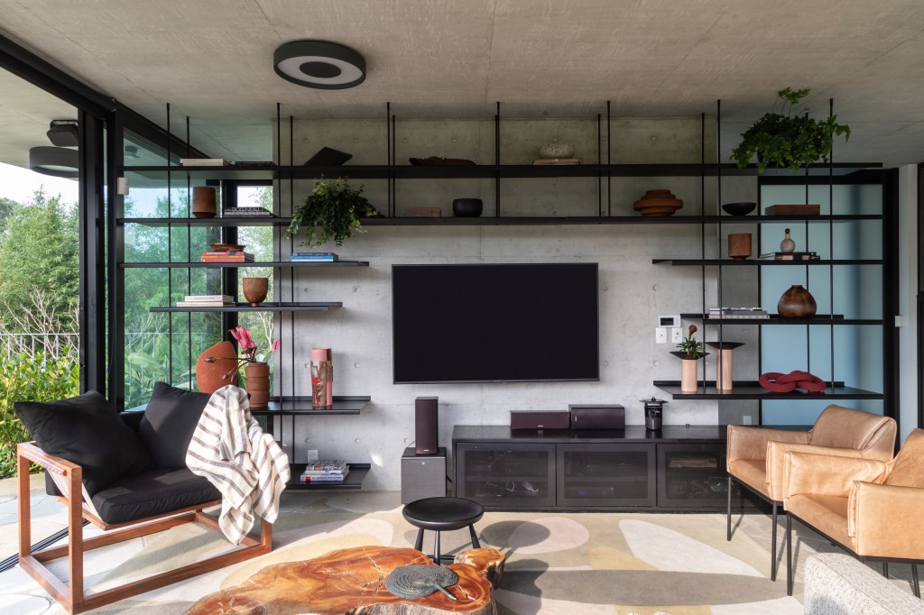 Sala de estar com concreto, madeira e tons neutros