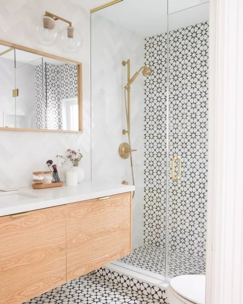 Este banheiro maravilhoso da Ashley Montgomery Design é a combinação perfeita de moderno o que está na moda. Ao manter as paredes simples e neutras, o designer deu destaque ao chuveiro e azulejos, criando interesse visual com este padrão estrelado. E ao estender os ladrilhos do chuveiro até o chão, o espaço parece mais amplo e aberto.