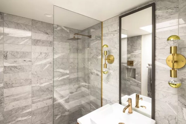 Esta elegante projeto da Michelle Boudreau Design não só apresenta acabamentos dourados maravilhosos, como também utiliza um mosaico de mármore subterrâneo que exala charme e classe. O mármore é um ótimo material em quase qualquer banheiro e uma ótima maneira de elevar o visual.