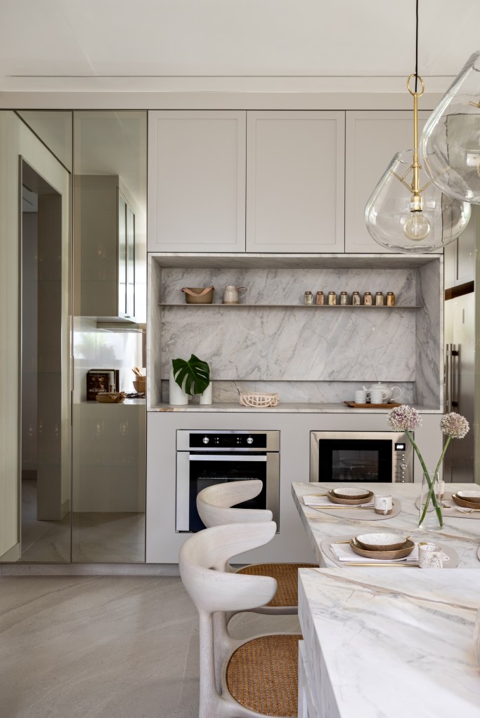 Cozinha com mármore e armários brancos