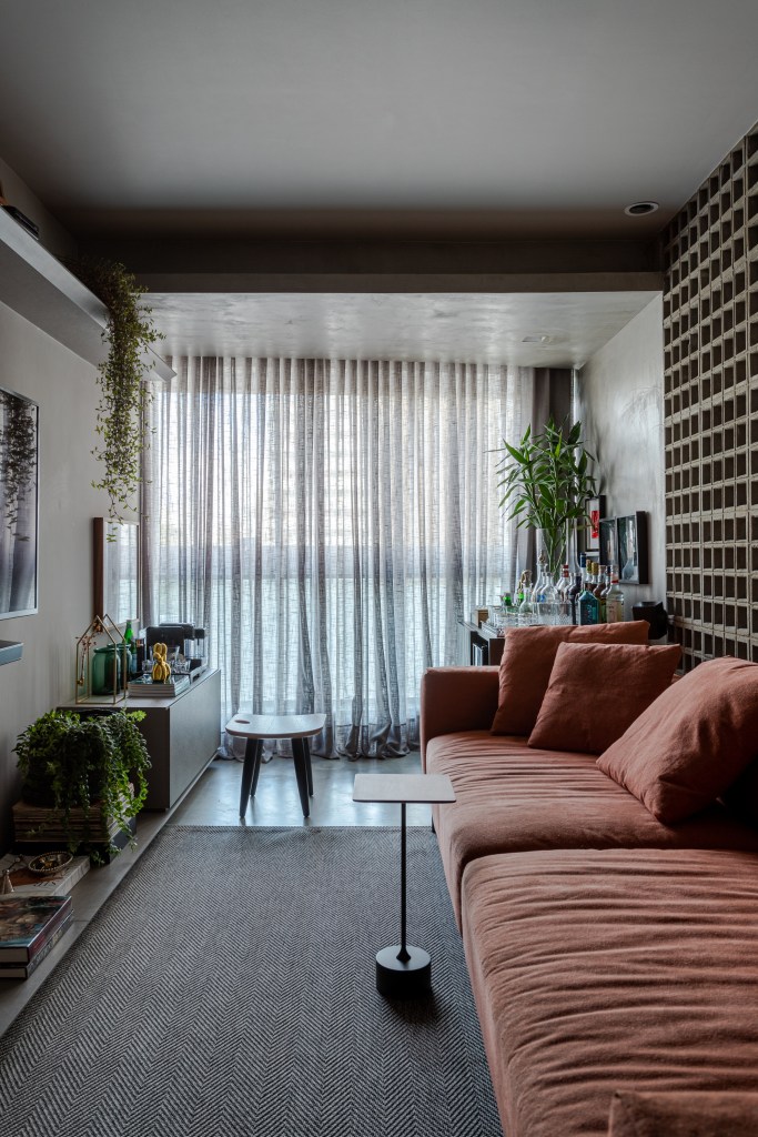 Sala elegante com sofá salmão e ampla janela.