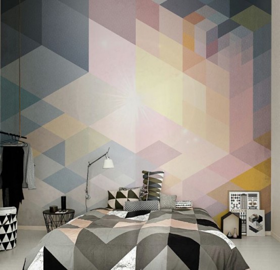 Quarto com parede da cabeceira decorada por papel de parede colorida em tons pastéis em uma padrão de trapézios. O edredom da cama também segue o mesmo tipo de padrão, porém em tons escuros.