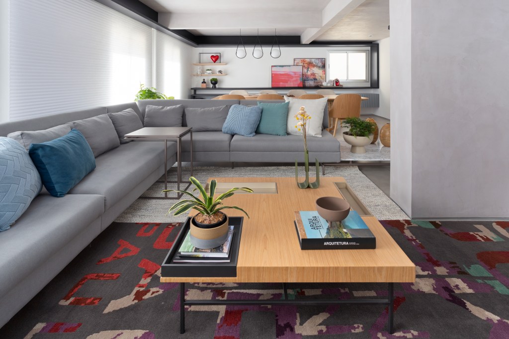 Sala de estar integrada com sofá em L cinza