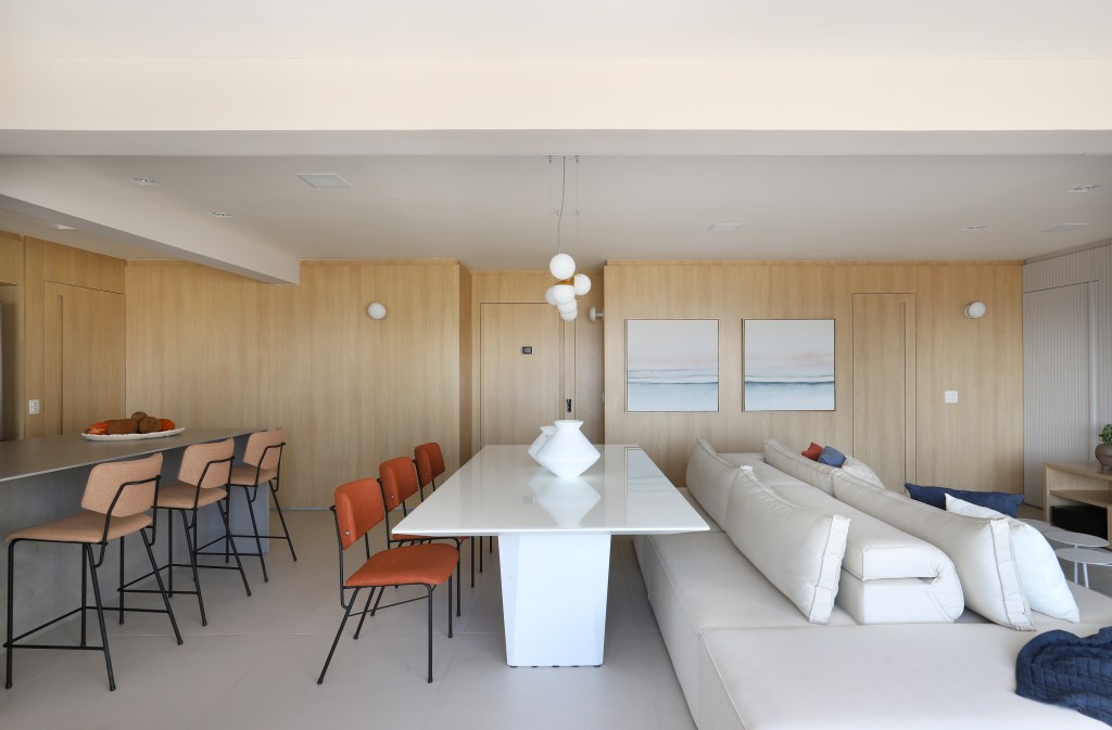 Sala de estar integrada com painel de madeira