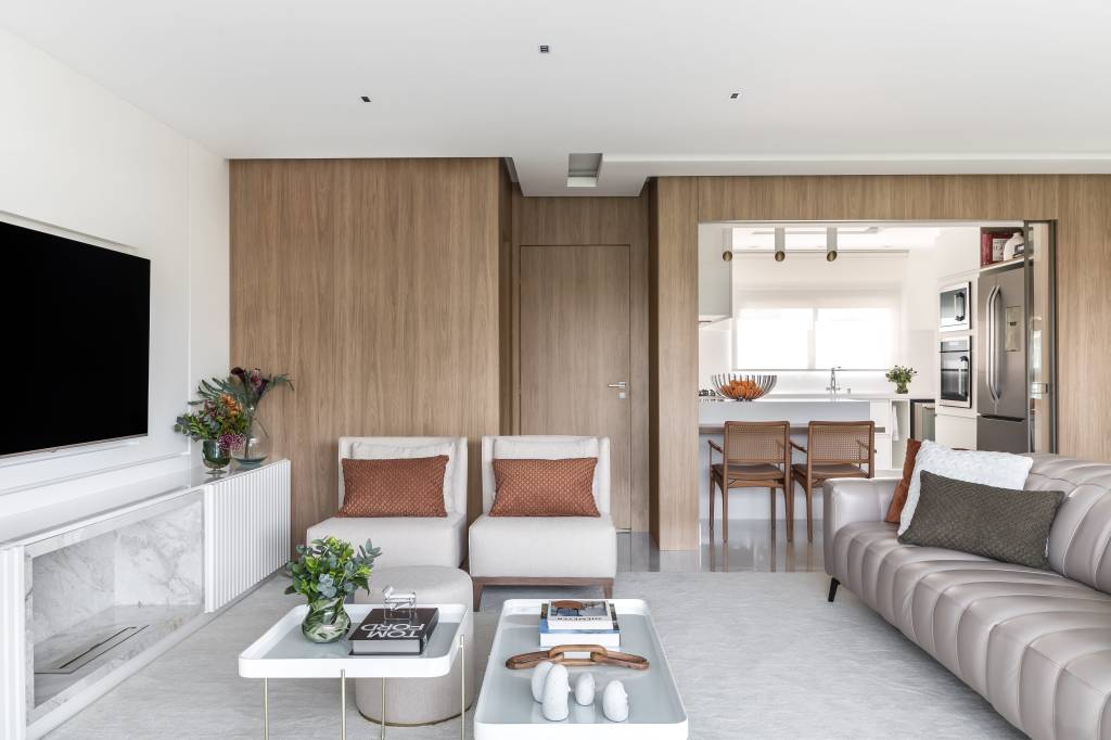 Sala com móveis e paredes em tons complementares de branco, bege e marrom.