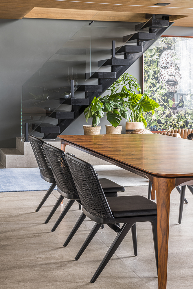 Sala de jantar com mesa em madeira; cadeiras pretas