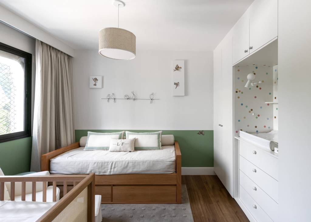 Quarto infantil com meia parede verde.; cama infantil e berço