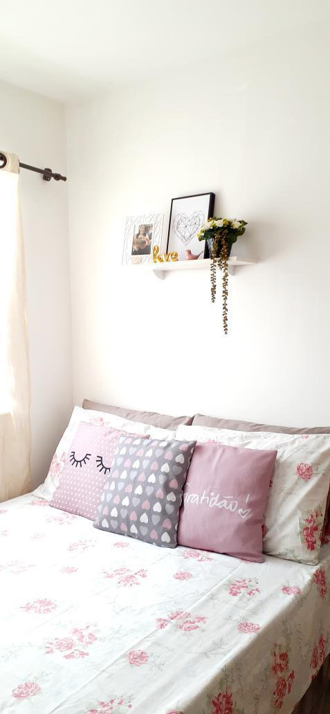 Meu cantinho: quarto com roupa de cama colorida e uma estante com vaso e quadros