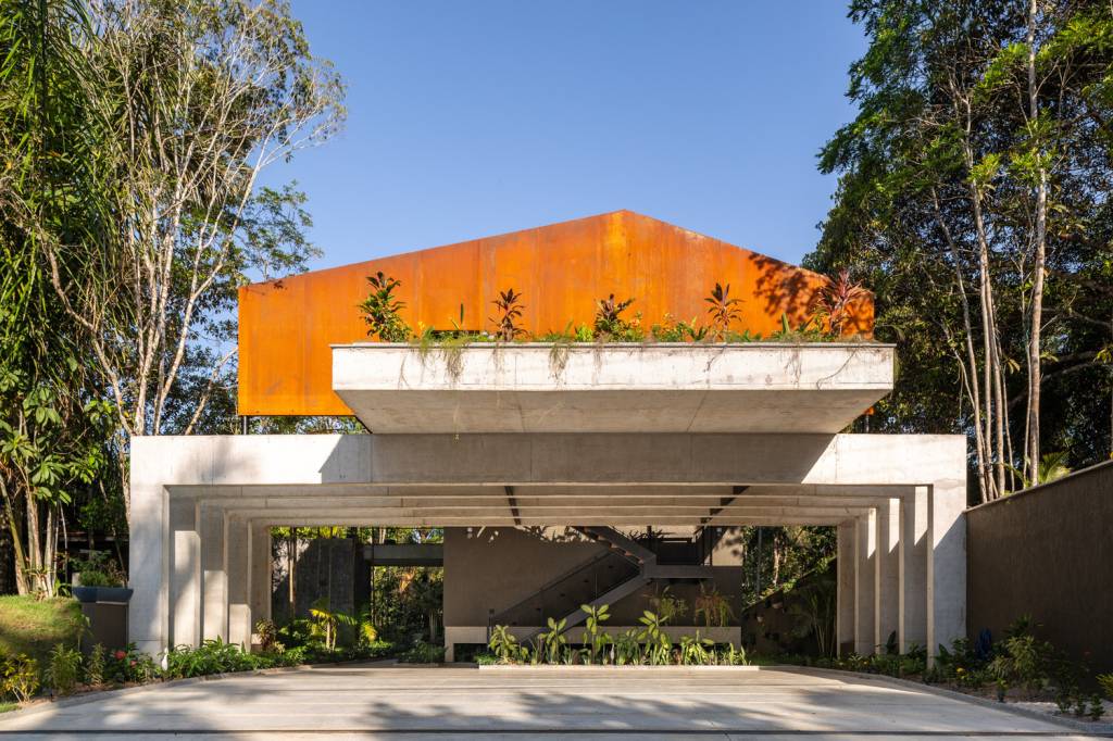casa-na-floresta-conforto-termico-menos-impactos-ambientais-joana-frança-telhado-aço-corten-platibanda-estrutura-concreto Foto mostra cobertura em aço corten e duas águas, com platibanda sobre estrutura de concreto.