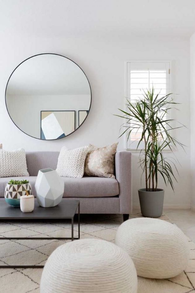 Sala de estar em estilo clean com sofá e pufes brancos