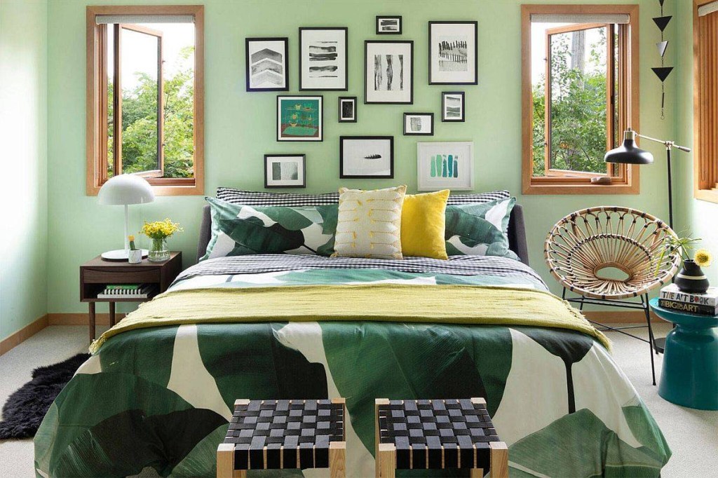 Quarto com parede de cabeceira verde pastel. A roupa de cama também tem detalhes em verde.