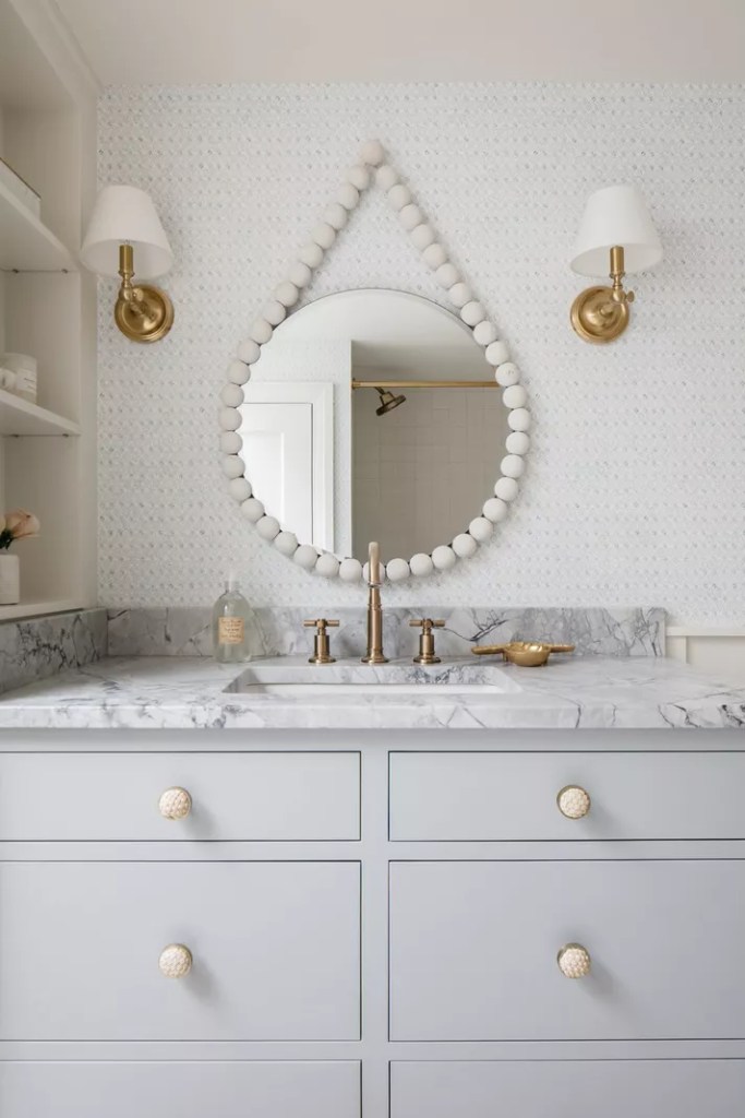 12 ideias fofas para decorar o banheiro-House of Chais-Kate Marker Interiors Banheiro com espelho circular alçado por uma espécies de colar de pérolas gigantes.