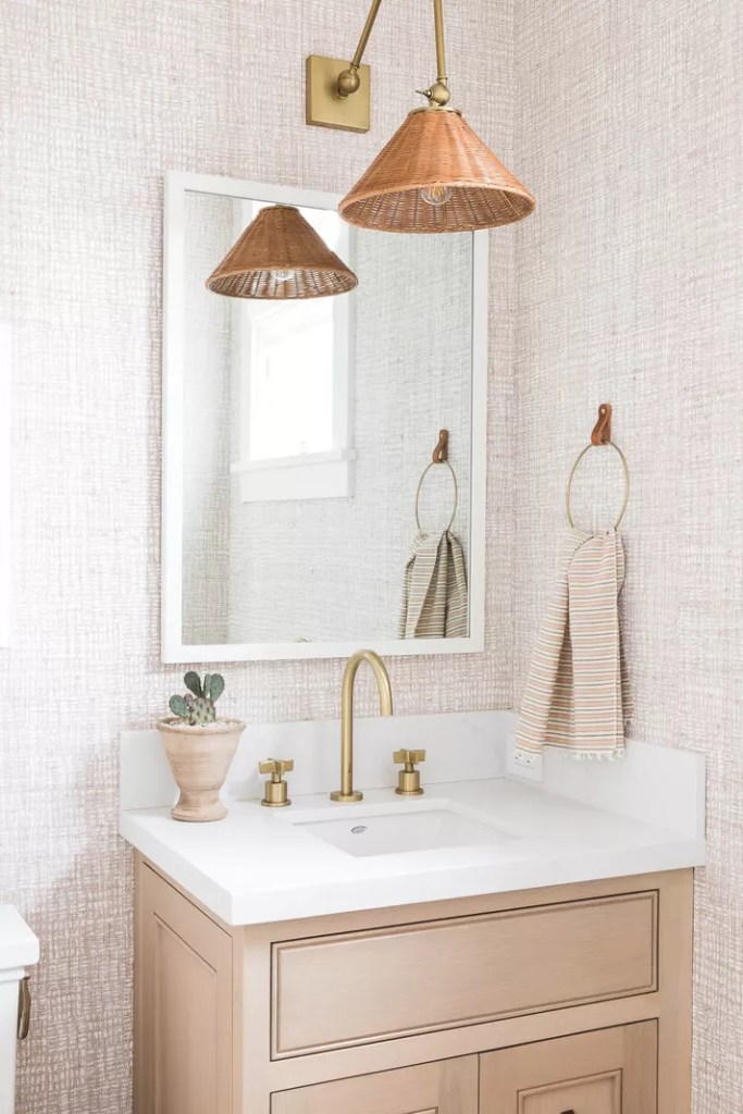 12 ideias fofas para decorar o banheiro-Mindy Gayer Banheiro com arandela de vime acima do espelho.