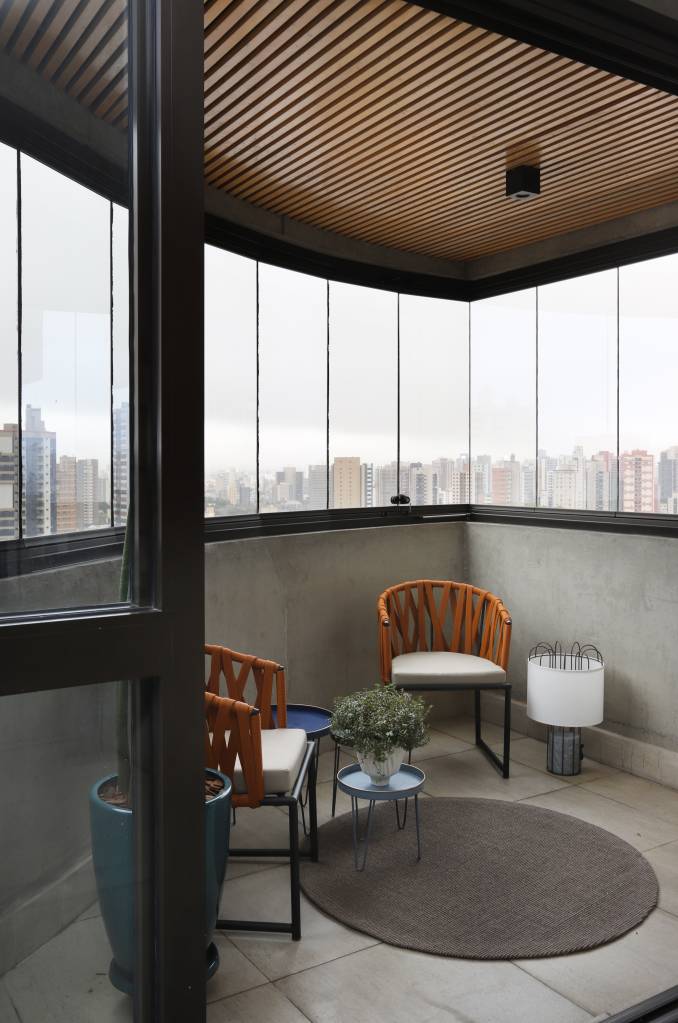 Varanda com duas poltronas e vista para São Paulo
