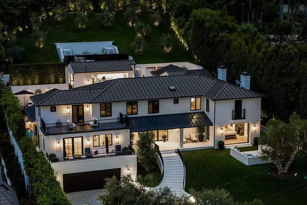 Casa de Rihanna em Beverly Hills, fachada branca com telhas cinzas e grande jardim na frente