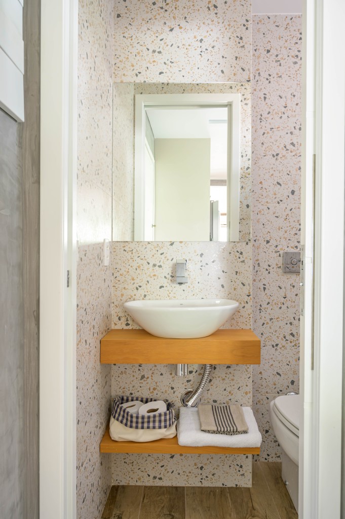 Banheiro com papel de parede e bancada de madeira