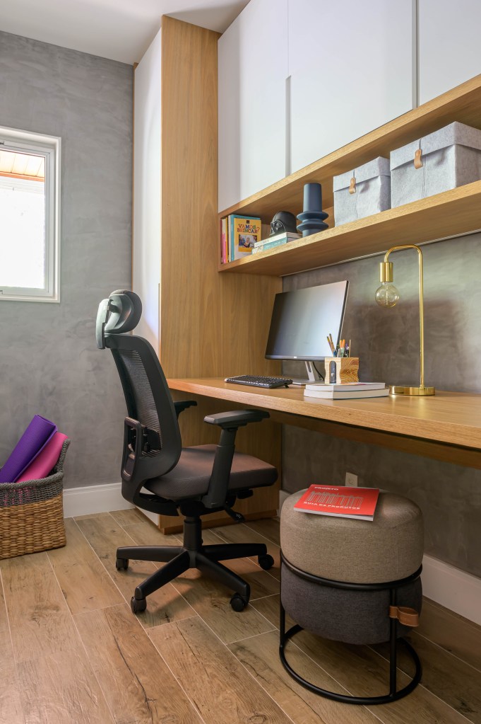 Home office com bancada de madeira e cadeira preta