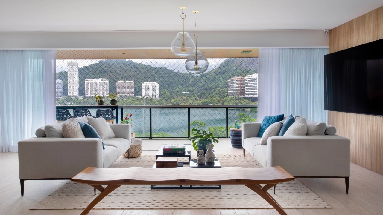 Sala de estar com vista para Lagoa com mesa de centro de madeira e sofá branco