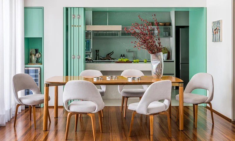 Sala de jantar integrada com cozinha por porta de correr; mesa de jantar; cadeira; marcenaria azul tiffany
