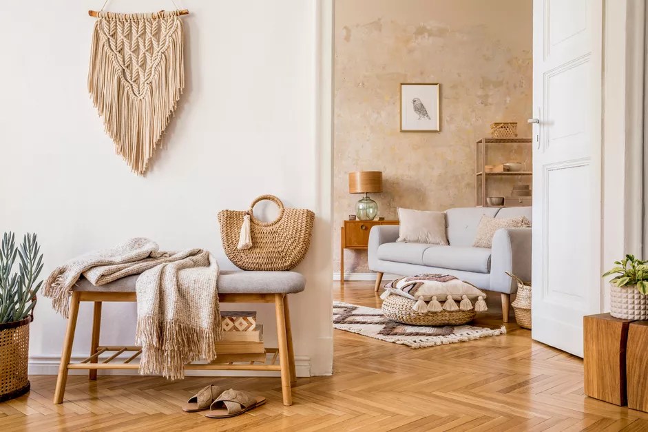 5-erros-comuns-de-quem-usa-o-estilo-Boho-GettyImages-FollowTheFlow Sala de estar em tons de bege e branco, decorada por móveis de madeira, sofá cinza claro e plantas.