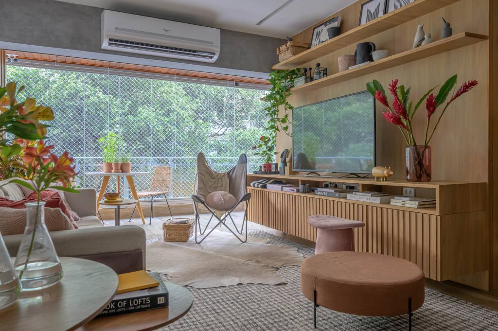 Sala de estar com viga de cimento queimado e painel de madeira