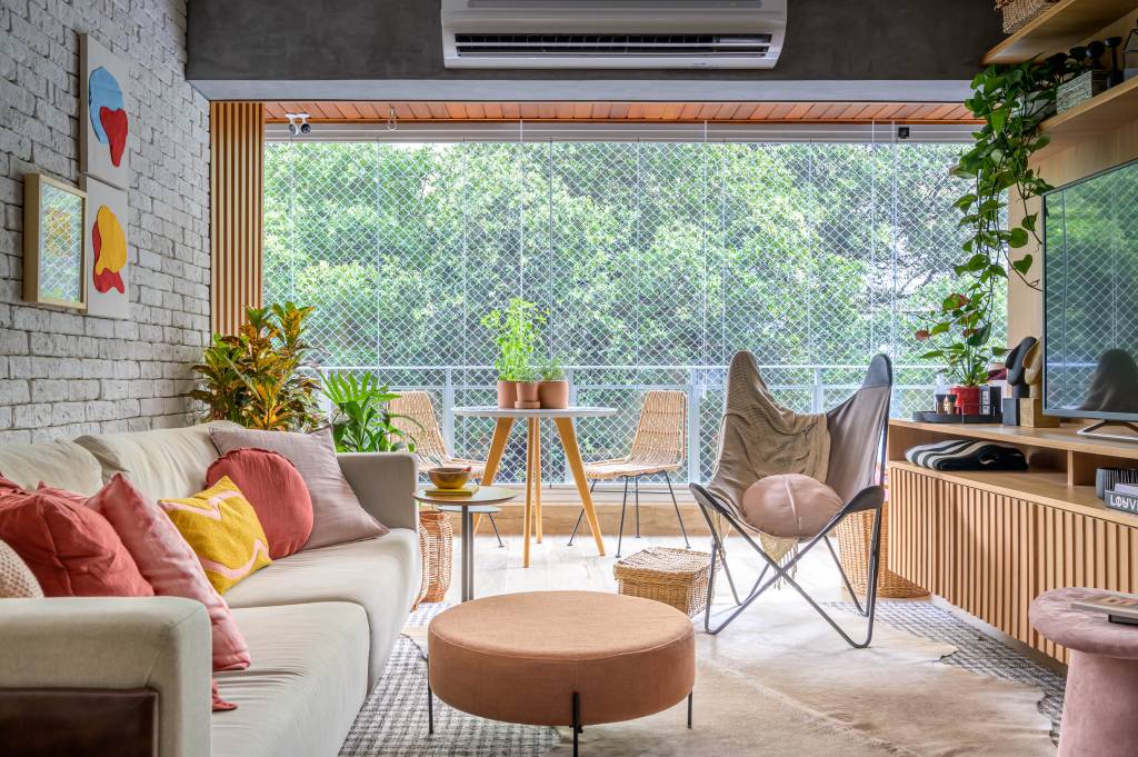 Sala de estar com vista para a natureza com tapete, sofá e poltrona