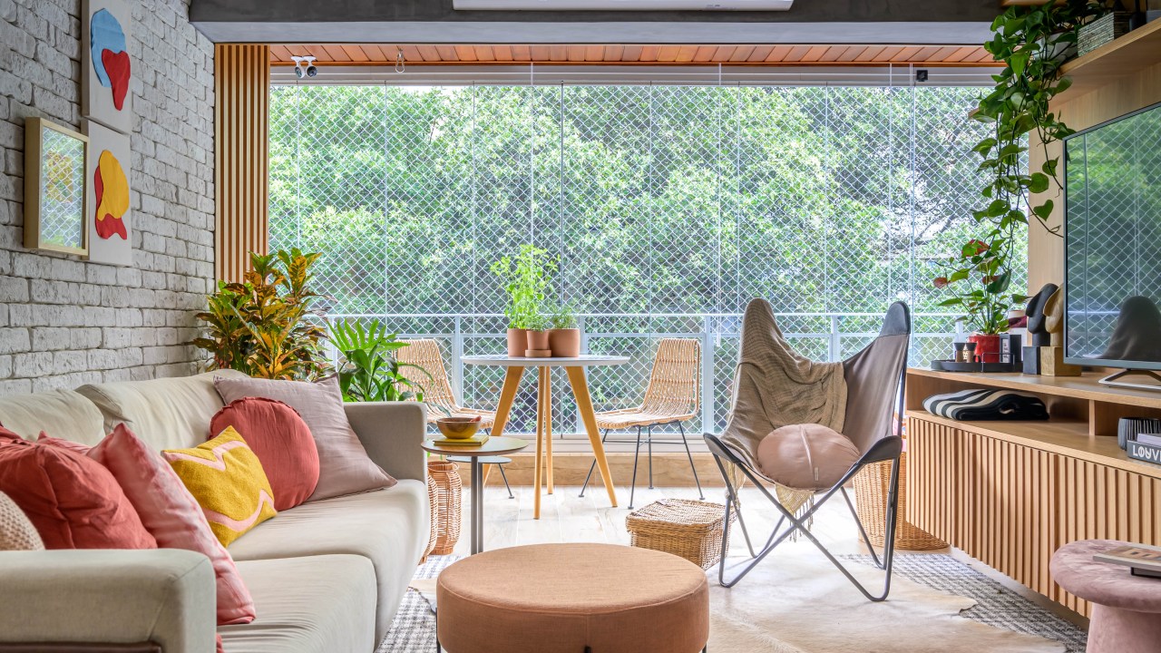 Sala de estar com vista para a natureza com tapete, sofá e poltrona