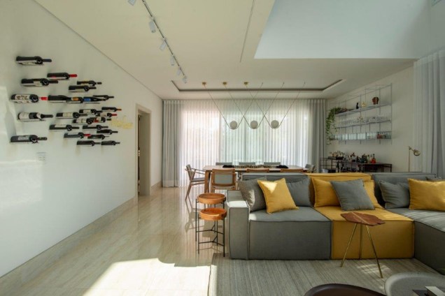 Nesse projeto desenvolvido para um casal o estilo escolhido foi o contemporâneo. Ele é marcado por linhas modernas e ainda possui elementos descontraídos, como o sofá com mescla de cores e a adega de parede.