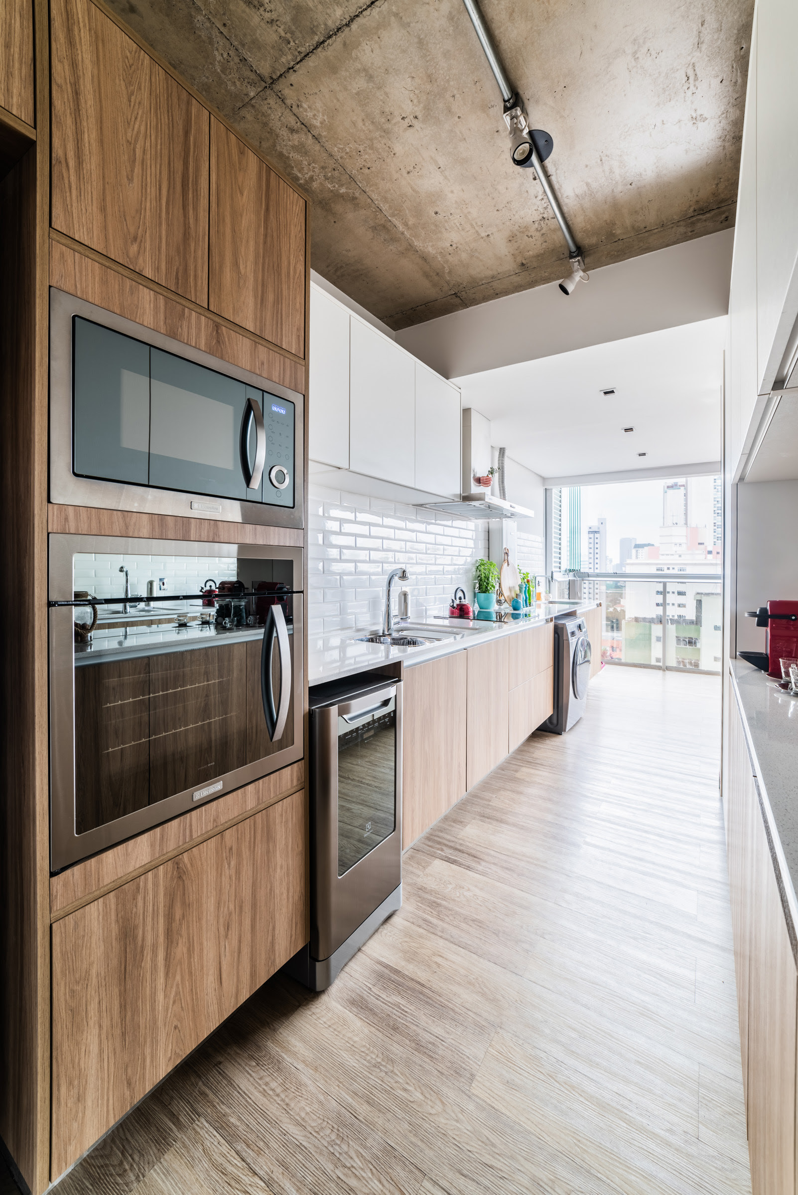 Nesta cozinha, os armários planejados ajudam a deixar o ambiente mais espaçoso. Com os móveis feitos sob medida, cada centímetro foi bem aproveitado, já que os eletrodomésticos se encaixam perfeitamente na marcenaria