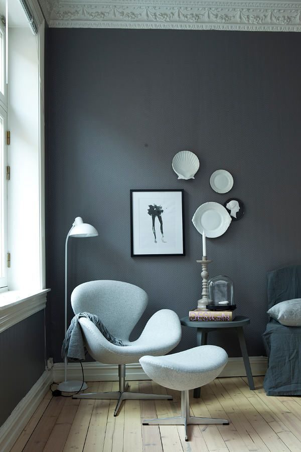 Sala com parede cinza escuro e poltrona cinza clara