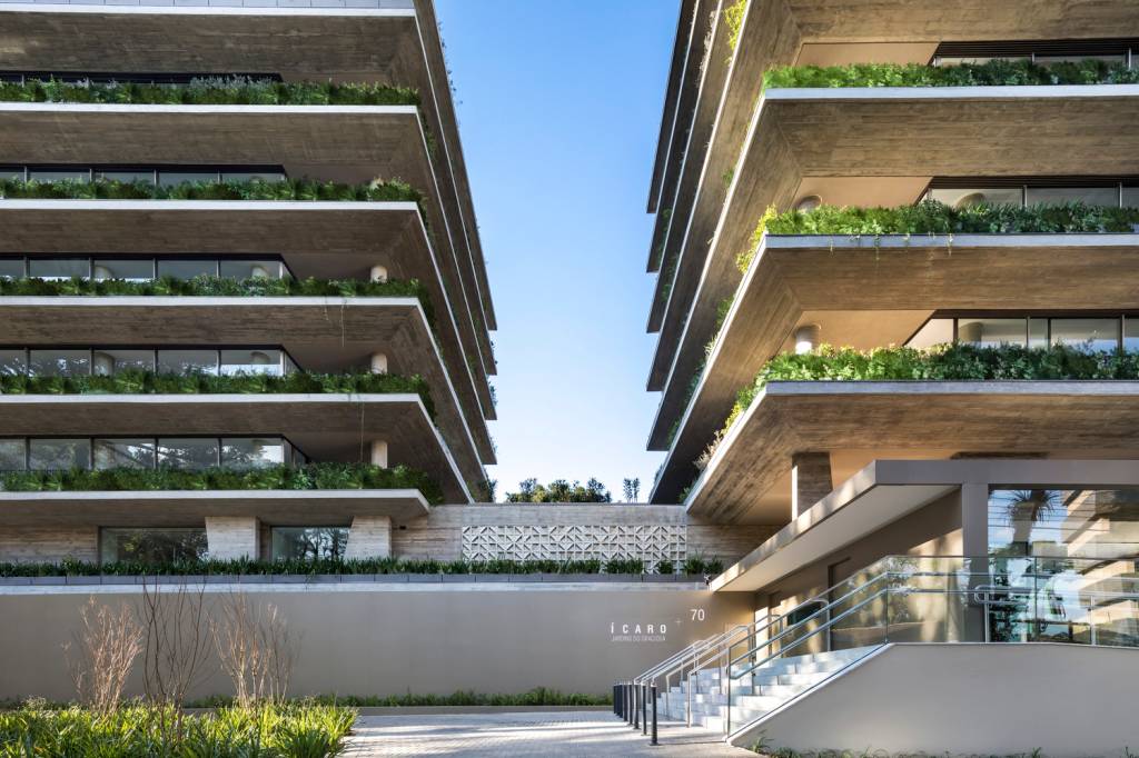 residencial-curitiba-recebe-certificacao-sustentavel-eduardo-macarios-fachada-verde-cobogo Foto mostra fachada de edifício residencial com abundância de plantas e floreiras nas varandas dos apartamentos.