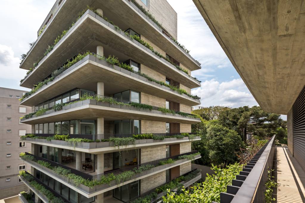 residencial-curitiba-recebe-certificacao-sustentavel-eduardo-macarios-fachada-verde-greenbuilding Foto mostra varandas de apartamentos com floreiras com vegetação abundante e jardins no condomínio.