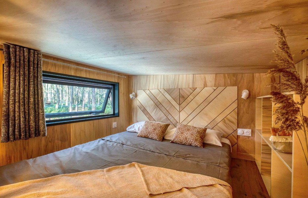 15 quartos pequenos e cheios de cor Decoist LoftNets Quarto com parede de cabeceira revestida e madeira com padrão chevron.