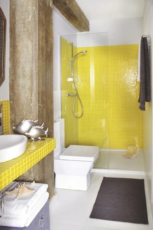 Banheiro com paredes e bancada de pia amarelas.