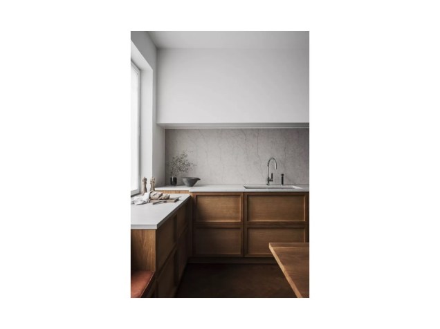 A moldura de madeira nas frentes dos armários proporciona um aspecto dimensional impressionante a este design de cozinha minimalista.