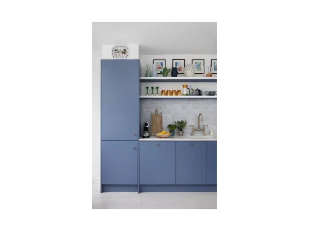 A cor azul suave dos armários traz um visual charmoso. Os puxadores combinados com a torneira de bronze e as prateleiras abertas agitam a aparência.