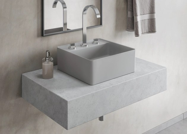 Foto em detalhe mostra bancada pequena de banheiro com cuba de apoio quadrada com mesa em tom semelhante.