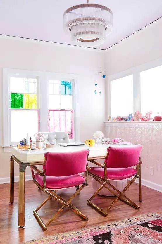 Home office de paredes brancas com destaque de cor para as cadeiras em rosa choque.