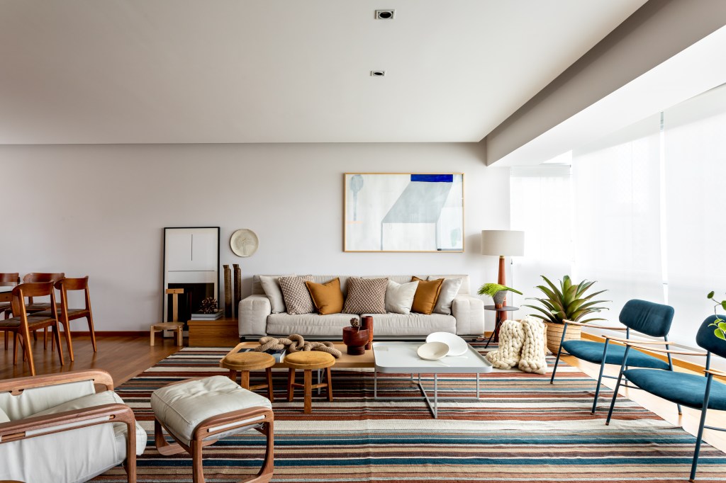 Grande sala oferece um elegante espaço de estar, com sofá, cadeiras e poltrona