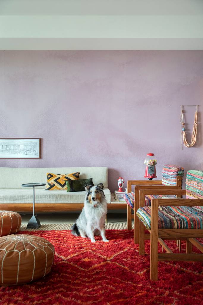 ape-96m-mix-estilos-moveis-vintage-guta-louro-fotos-denilson-machado-mca-sala-tapete-boho Sala de estar em estilo boho; sofá branco; parede rosa; tapete vermelho; cachorro