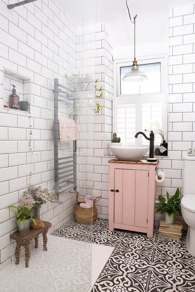 Banheiro pequeno com box de vidro; armário pequeno rosa