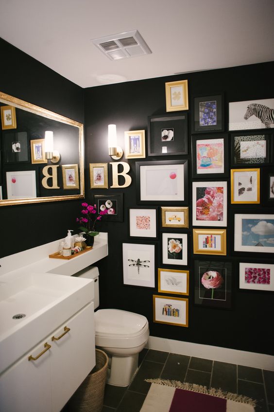 d-appliances-a-bright-gallery-wall-a-mirror-and-wall-sconces-is-a-cool-space Banheiro com uma parede repleta de quadros.