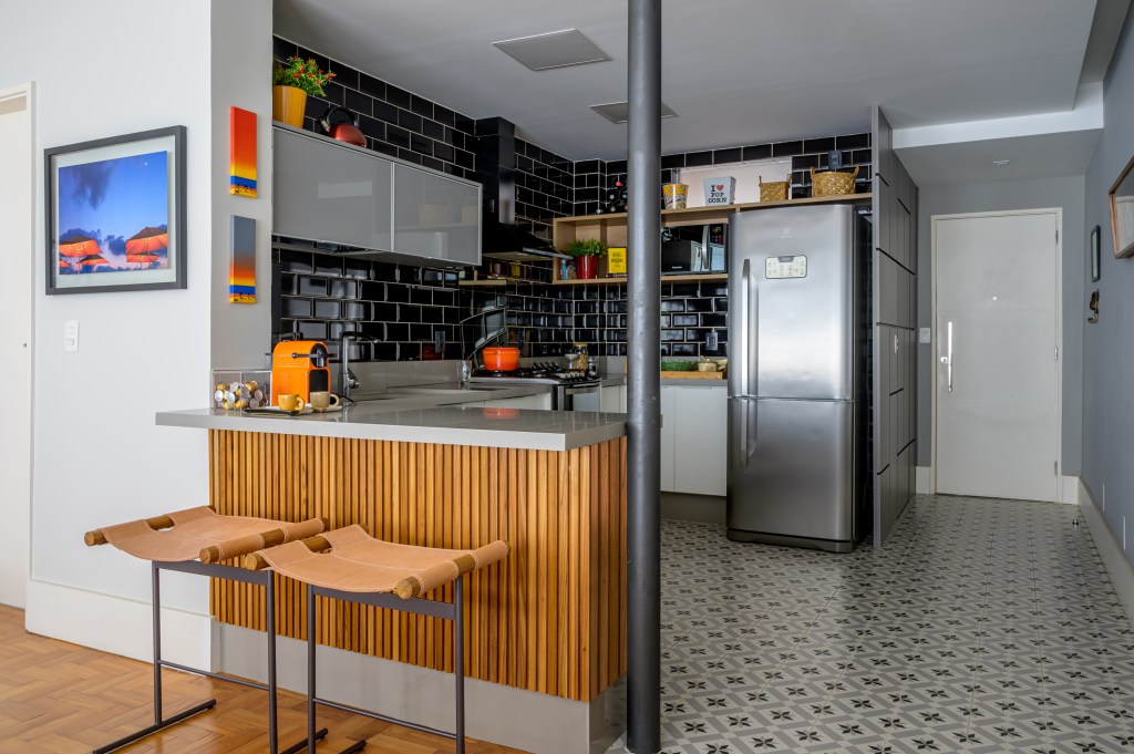 Cozinha integrada com bancada; piso geométrico; parede com tijolinhos pretos