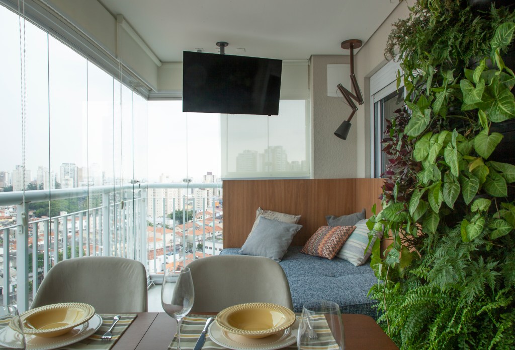 Varanda gourmet com sofá e jardim vertical
